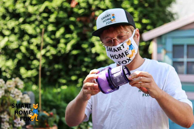 Очистка фильтра аккумуляторного пылесоса на открытом воздухе, над мусорным контейнером